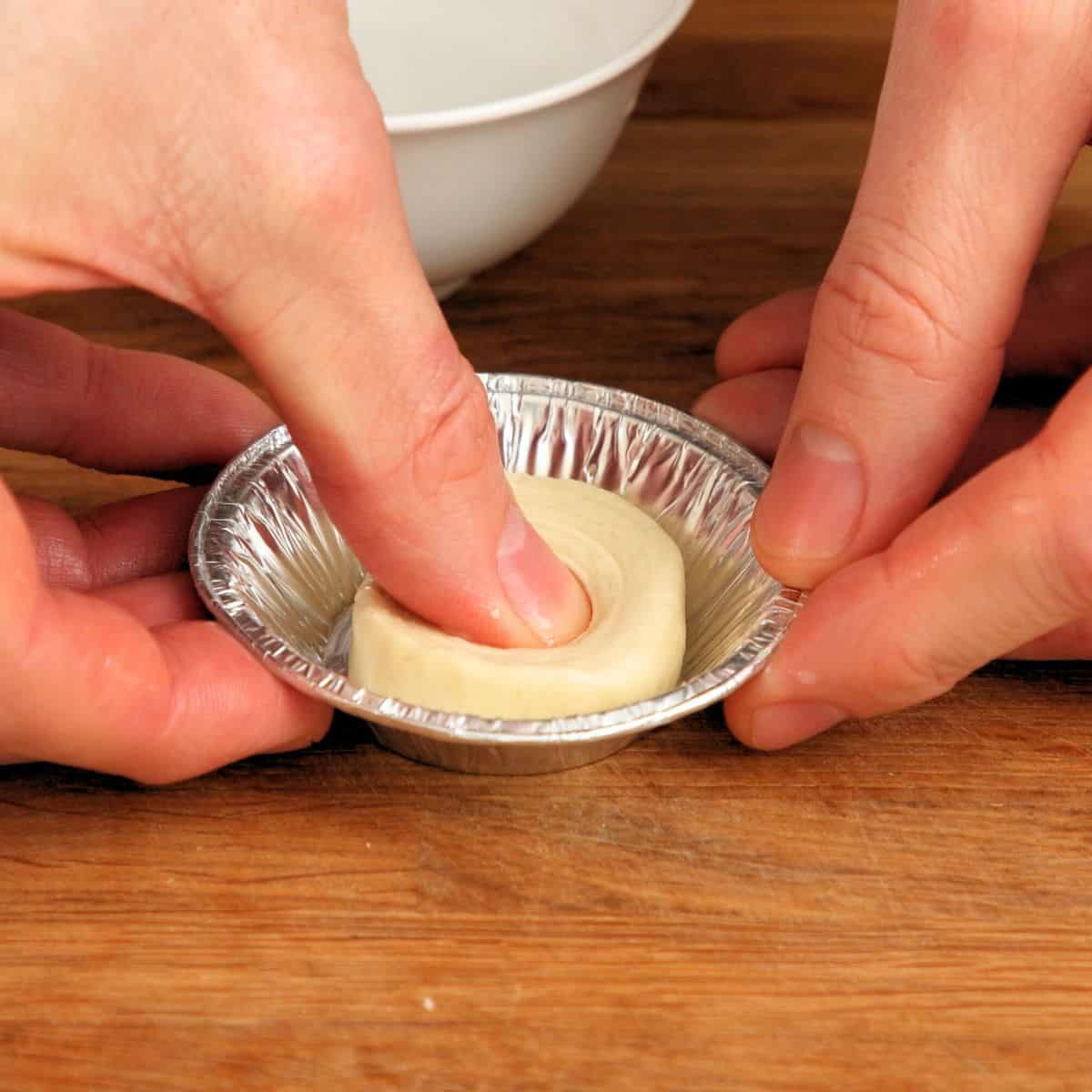 Pressing pastry into mold.