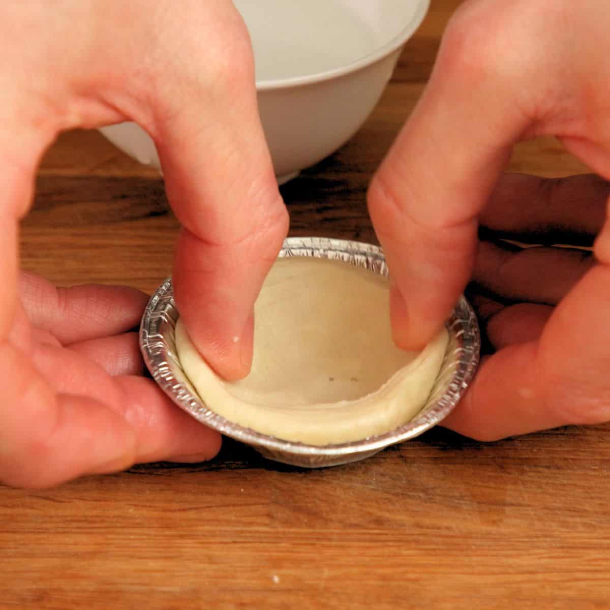 Pressing pastry into mold.