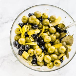 marinated black and green olives in a glass bowl