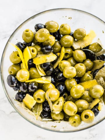 marinated black and green olives in a glass bowl