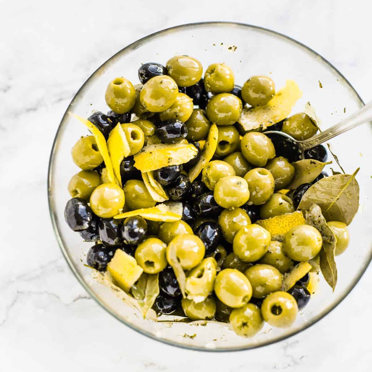 marinated black and green olives in a glass bowl