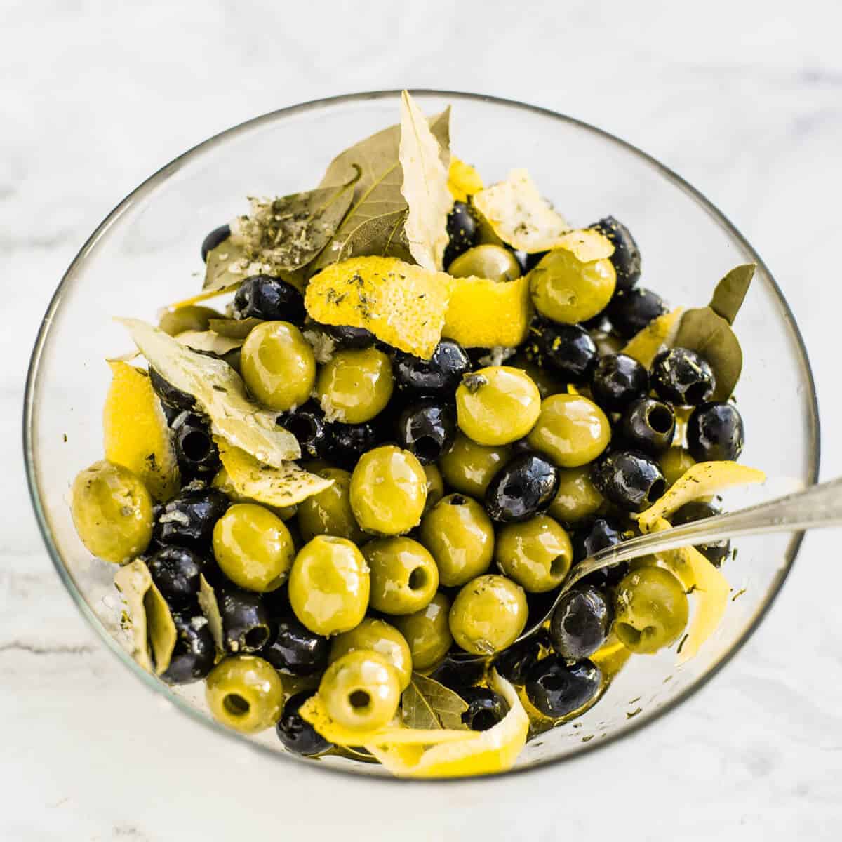 marinated black and green olives in a glass bowl
