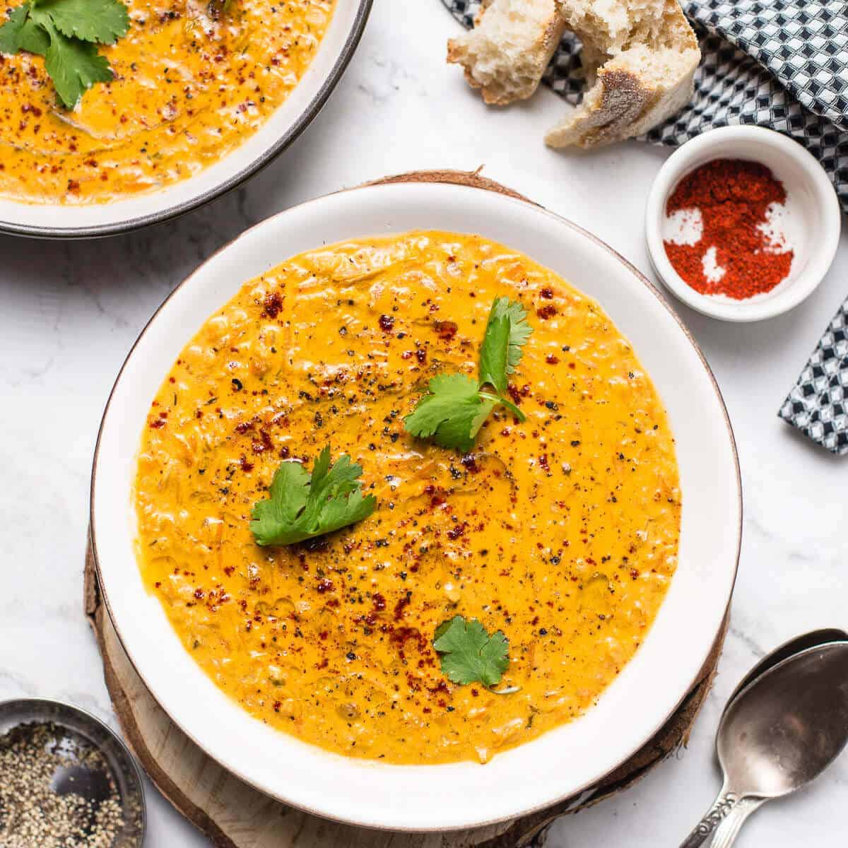 red lentil soup with cilantro in a white bowl