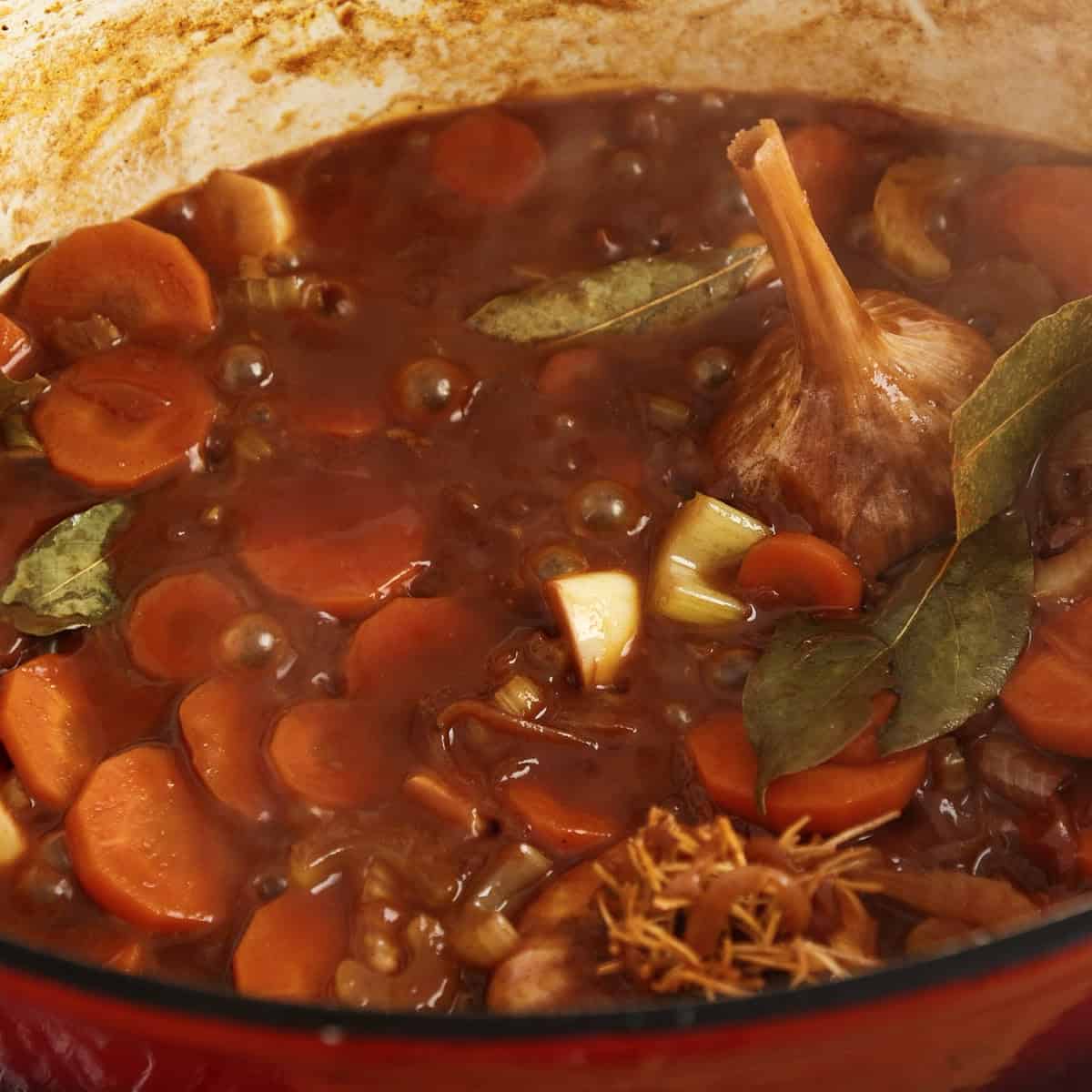 Reduced red wine with vegetables in a casserole dish.
