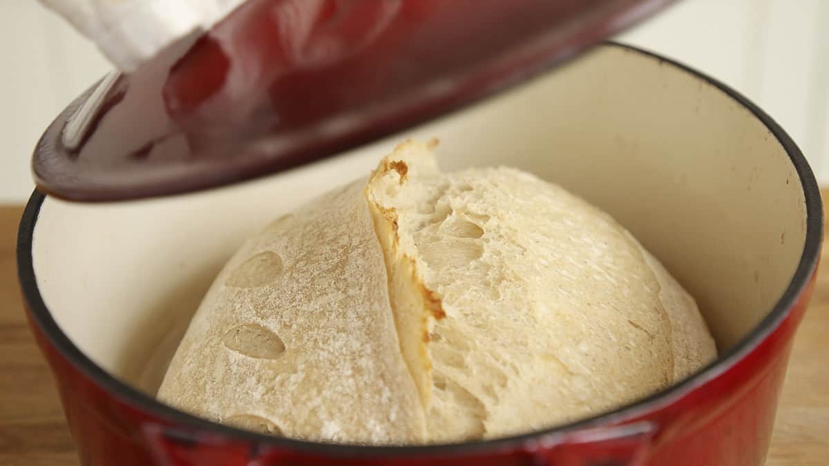 Half baked sourdough loaf in a red dutch oven.