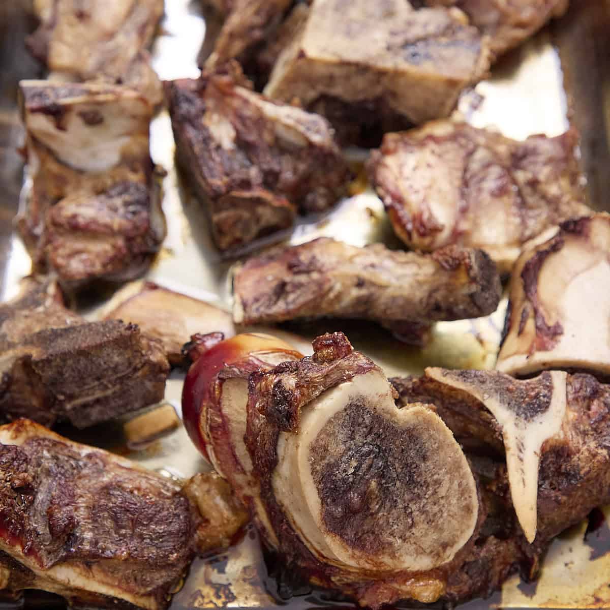Beef bones roasted on a sheet pan.