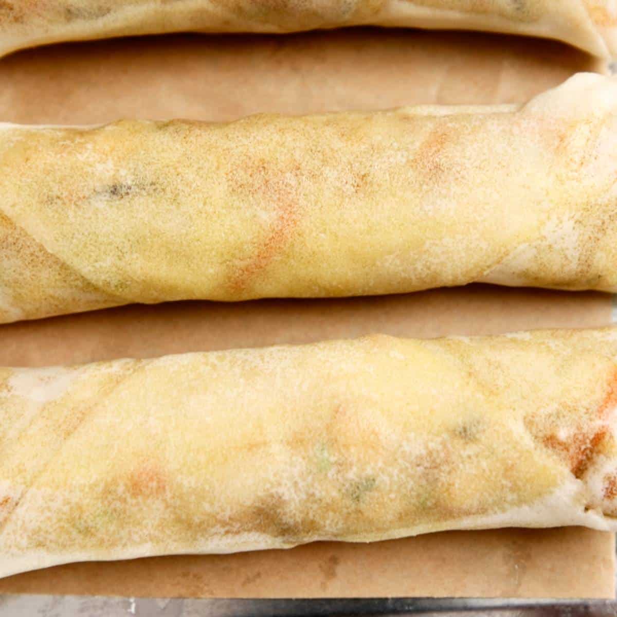 Rolled spring rolls on a tray.
