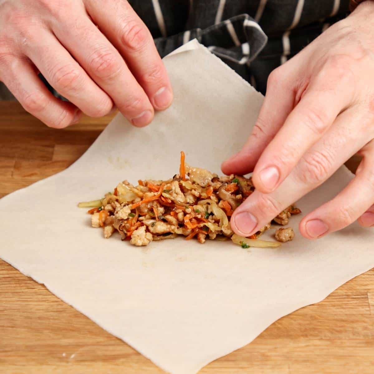 Placing filling onto spring roll pastry.