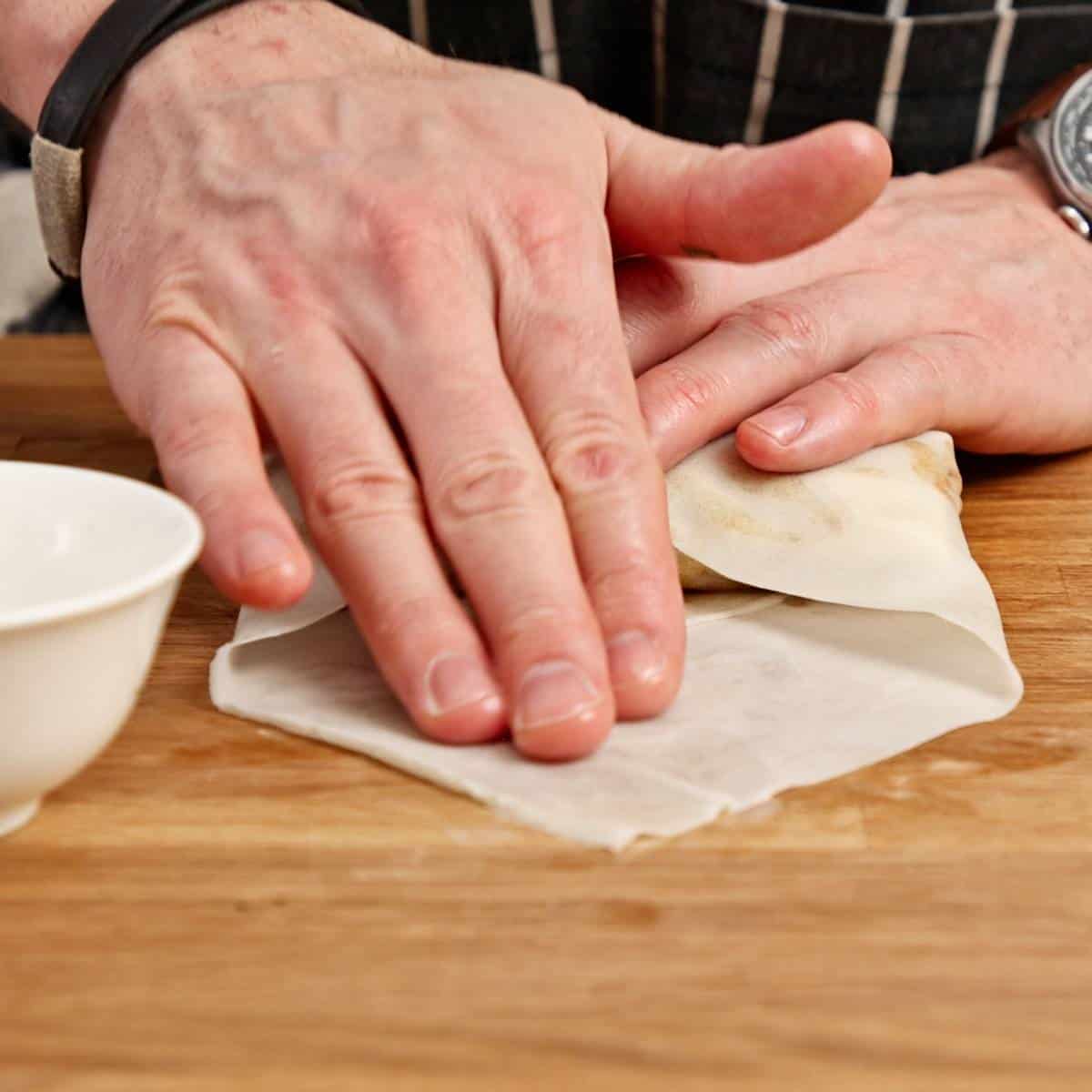 Sealing a spring roll with cornstarch slurry.