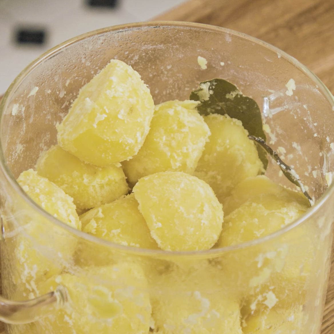 Roughed up boiled potatoes in a pot.