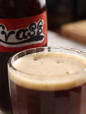 Black bread kvass in a beer glass on white table.