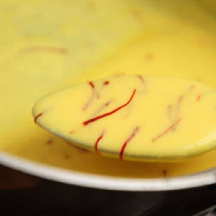 Saffron sauce on a spoon, showing the correct consistency when done.