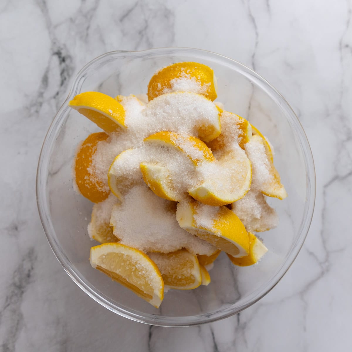 Cut lemons with salt in a glass bowl.