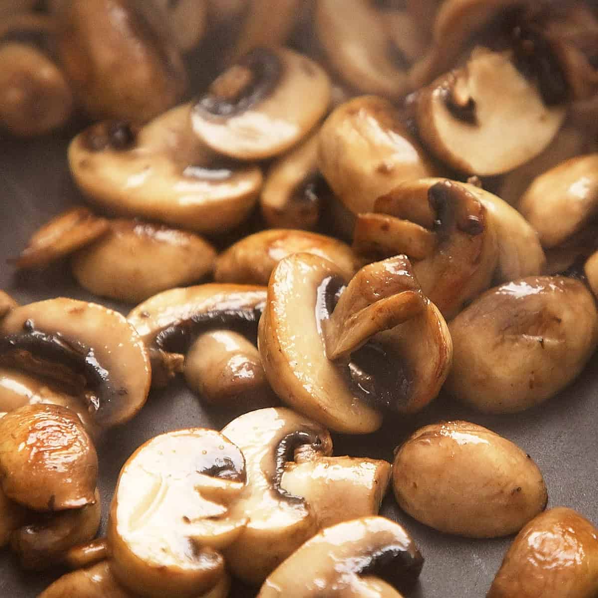 Browning mushrooms in a pan.