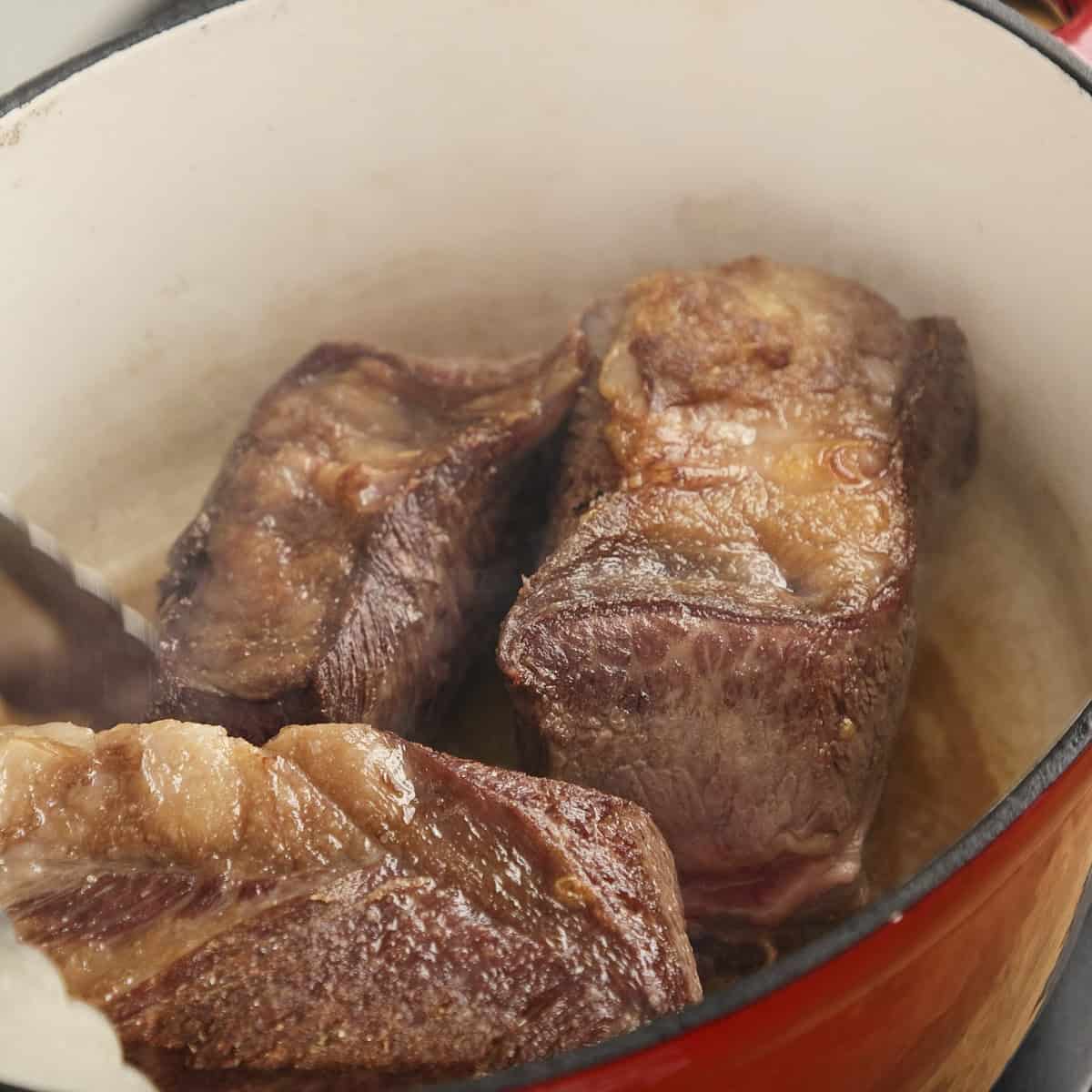 Searing beef short ribs in a casserole.