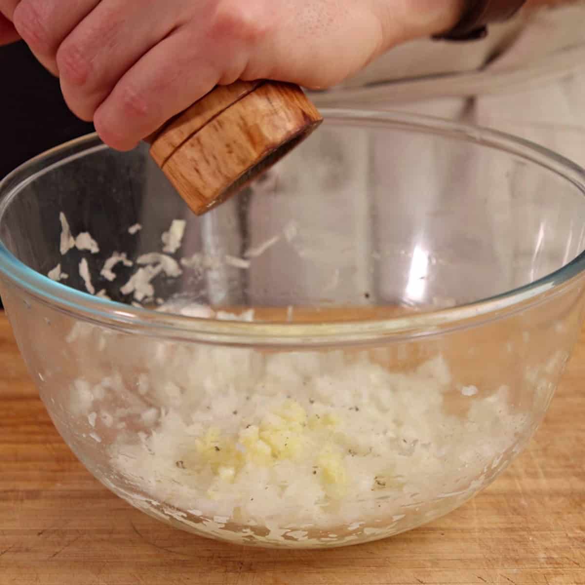 Seasoning meat filling in a glass bowl.