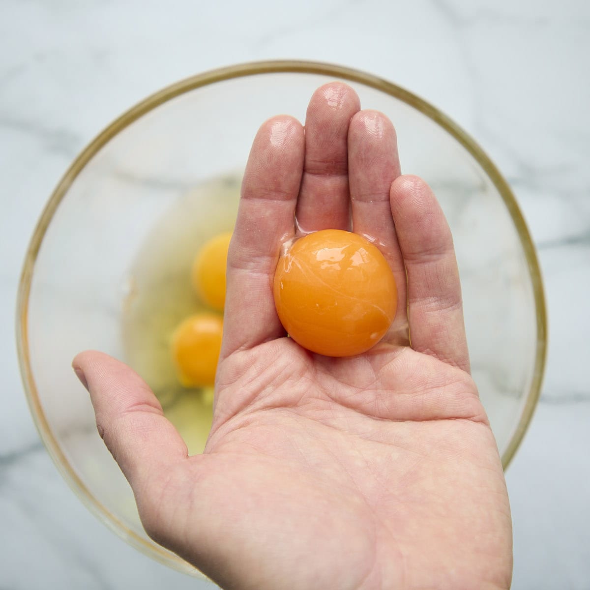 Separating egg yolk from egg white by hand.