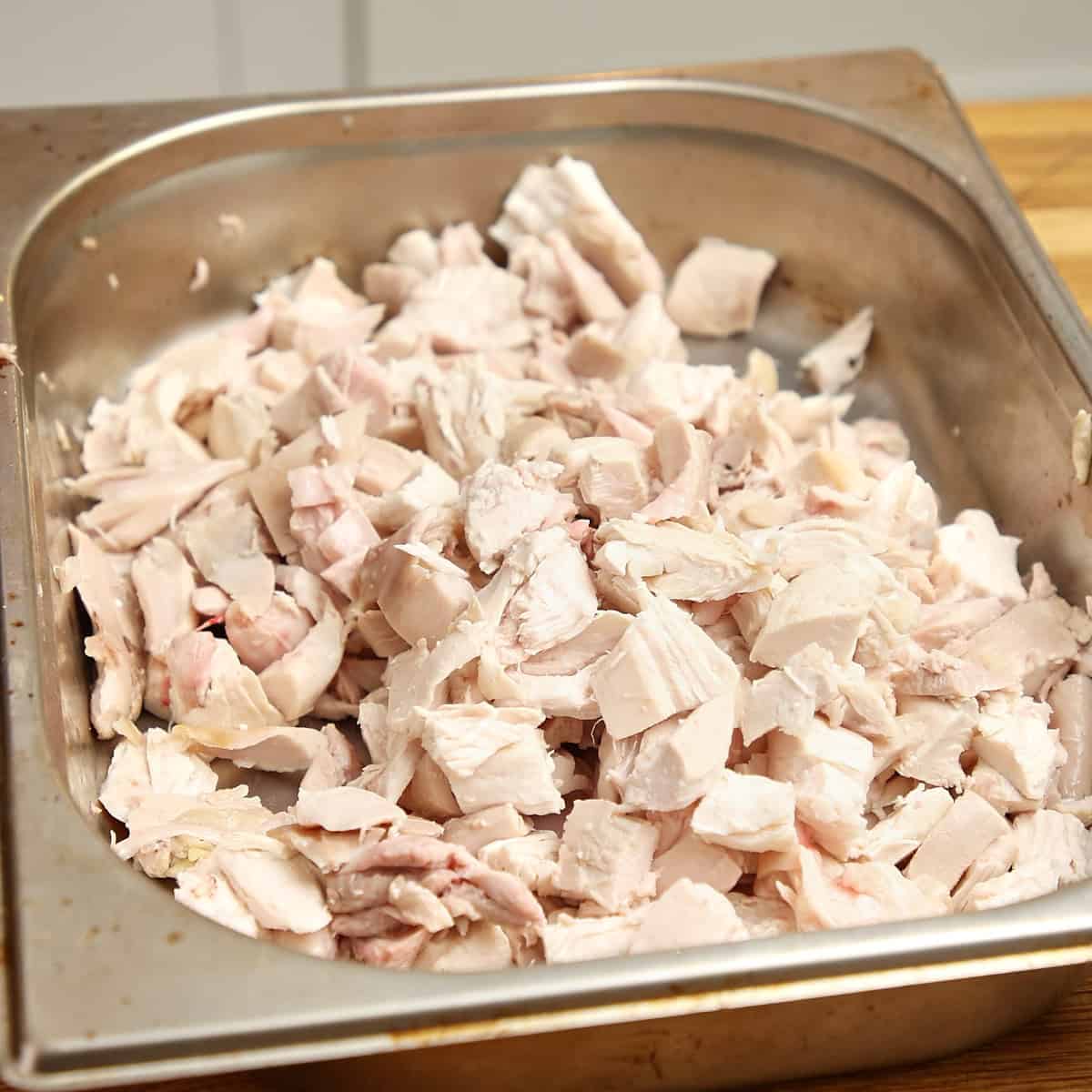 Picked roasted chicken in a stainless steel tray.