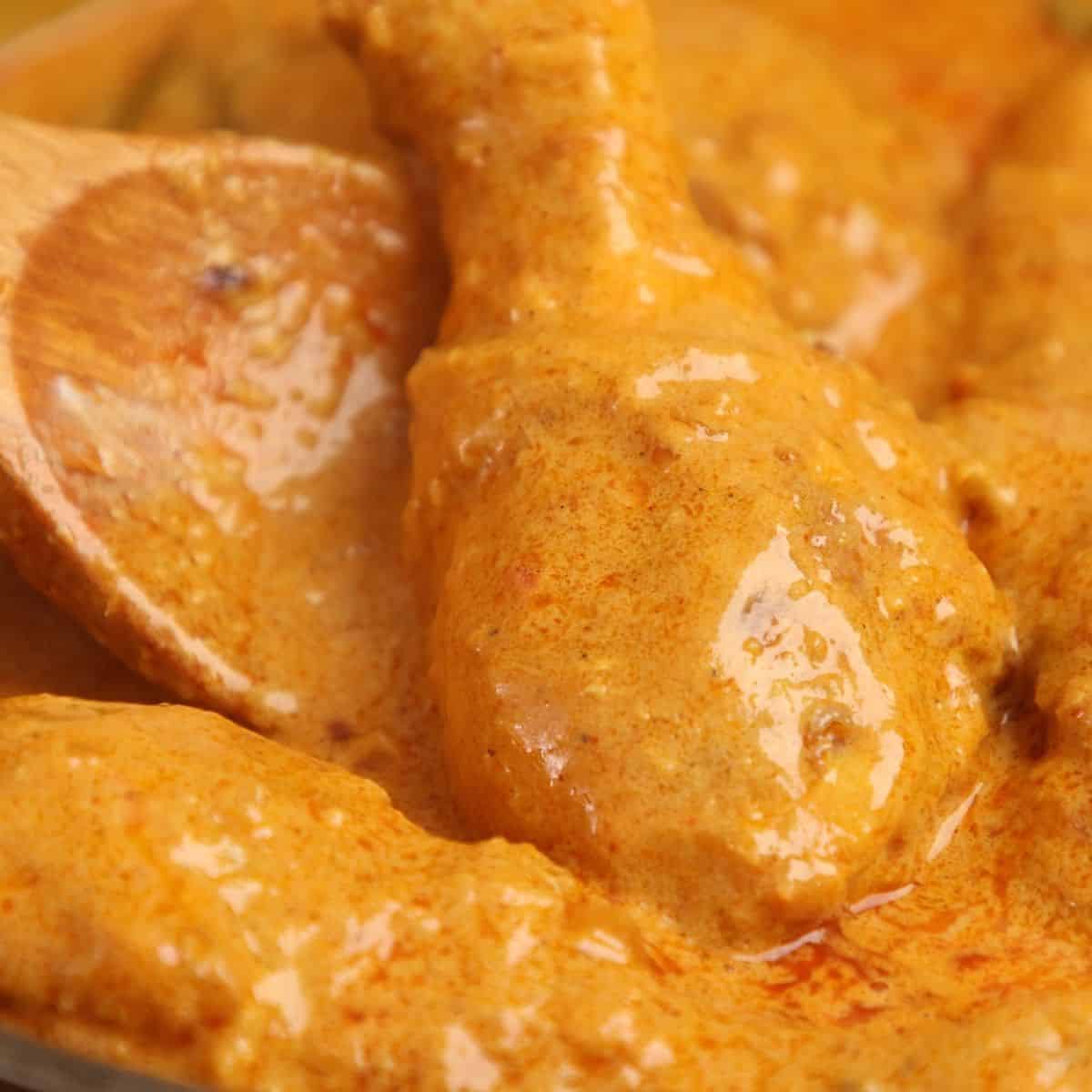 Simmering chicken in a rich curry gravy.