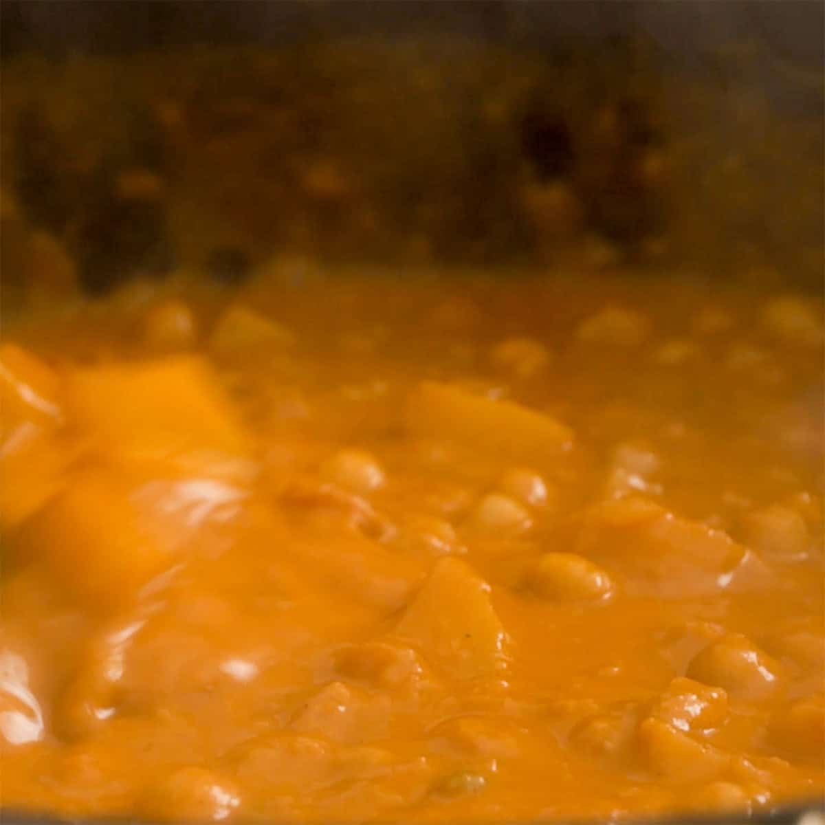 Curry simmering in a black sauce pan.