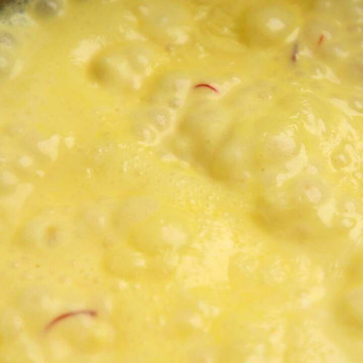 Saffron sauce simmering in a saucepan.