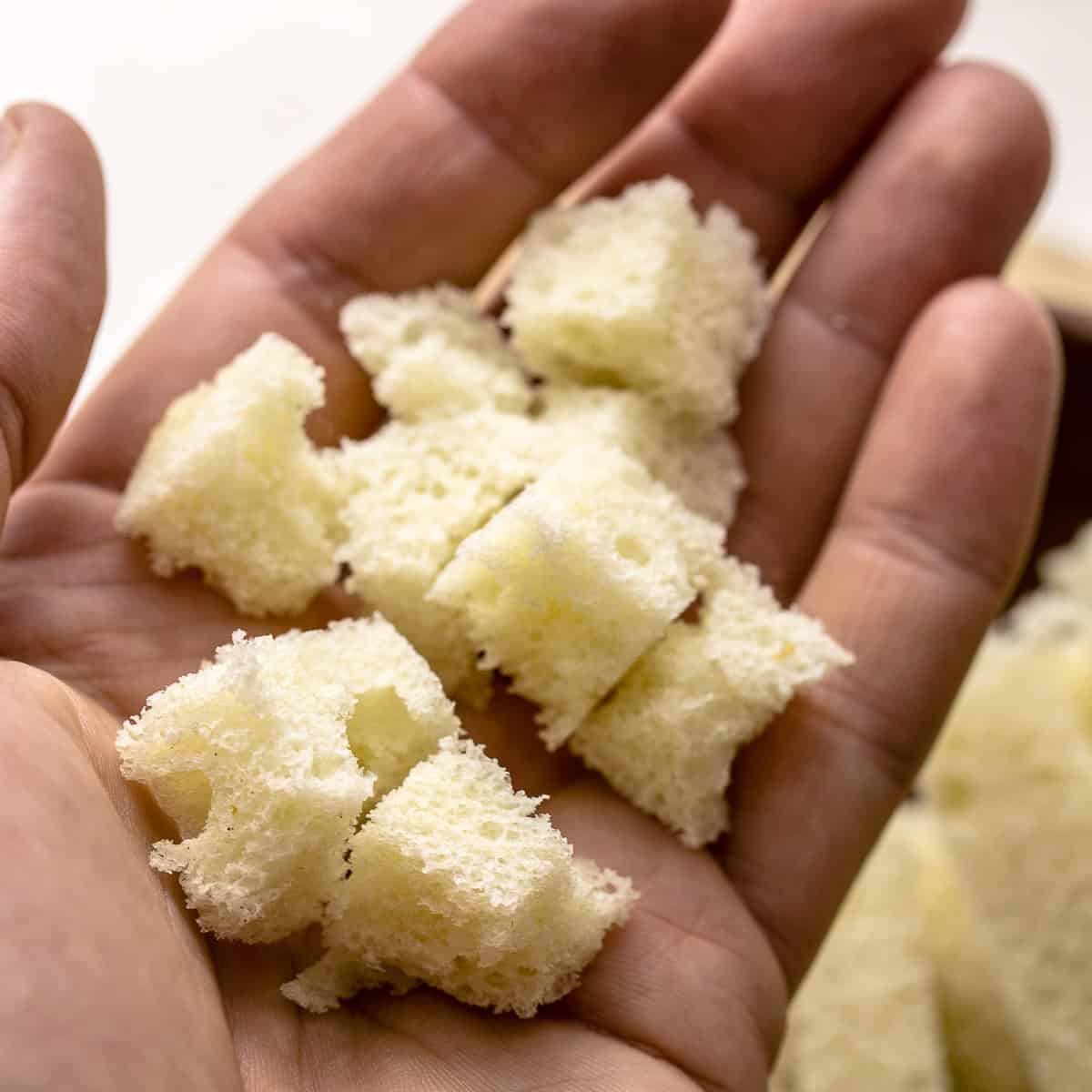 Brioche bread pieces in hand.