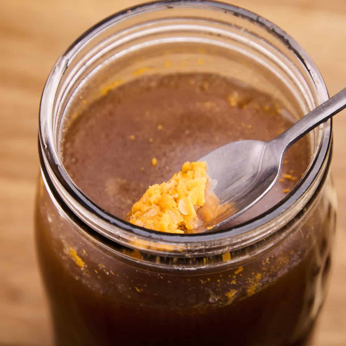 Skimming solidified fat off beef stock.