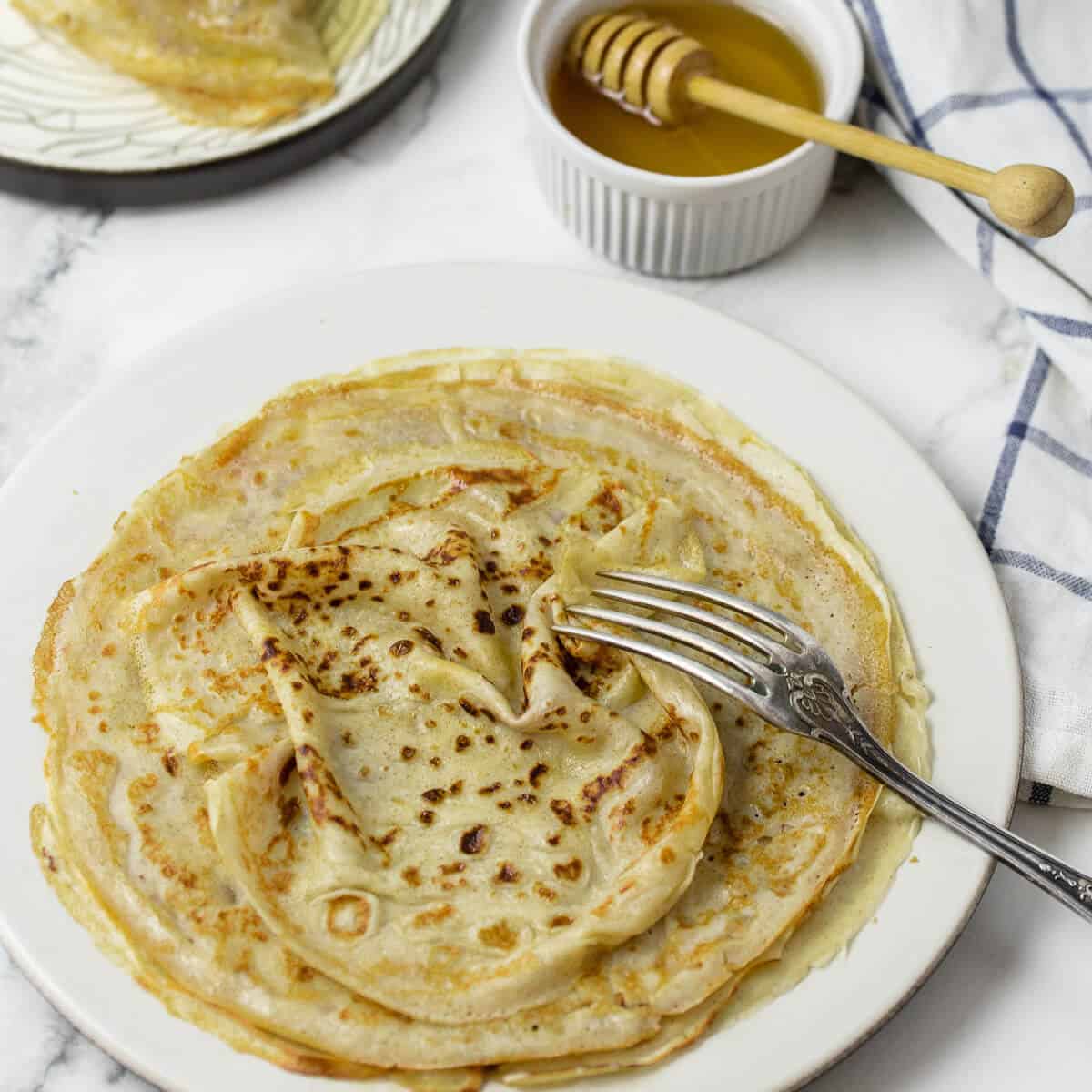 Sourdough discard crêpes on a white plate.