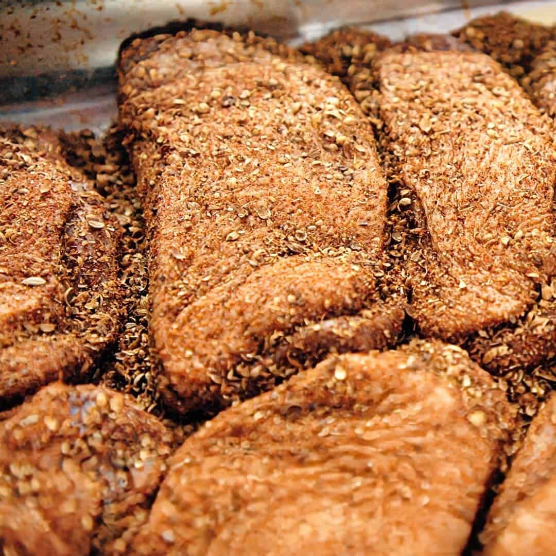 Raw duck breast in a mixture of spices.