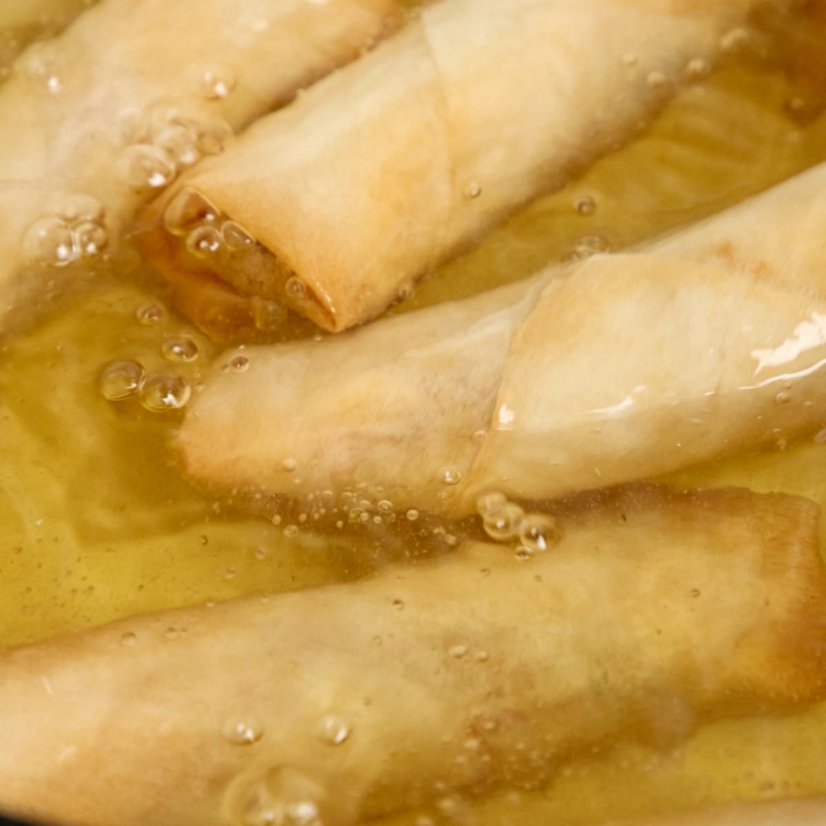 Frying spring rolls in oil.