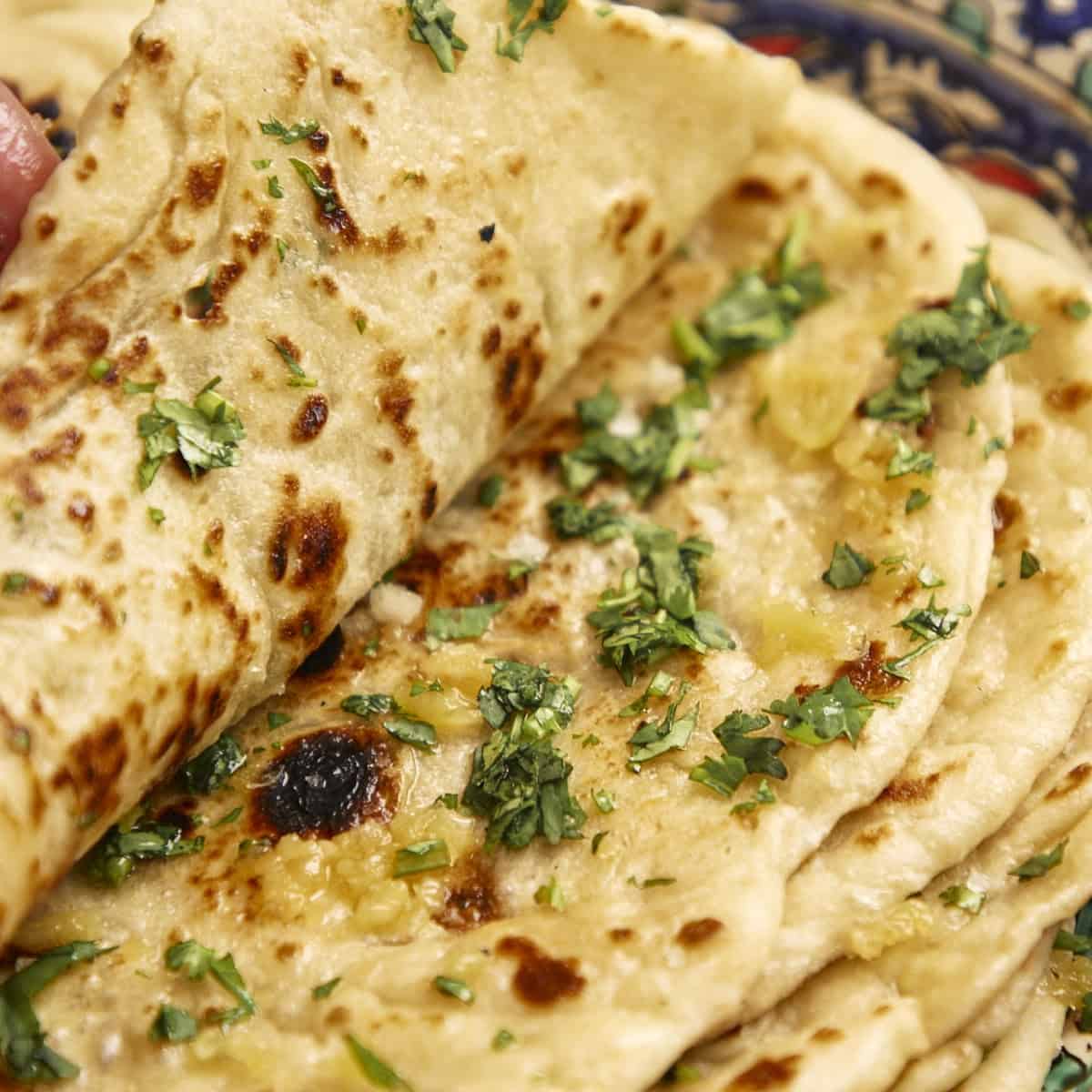 Stacked naan with herbs and garlic butter.