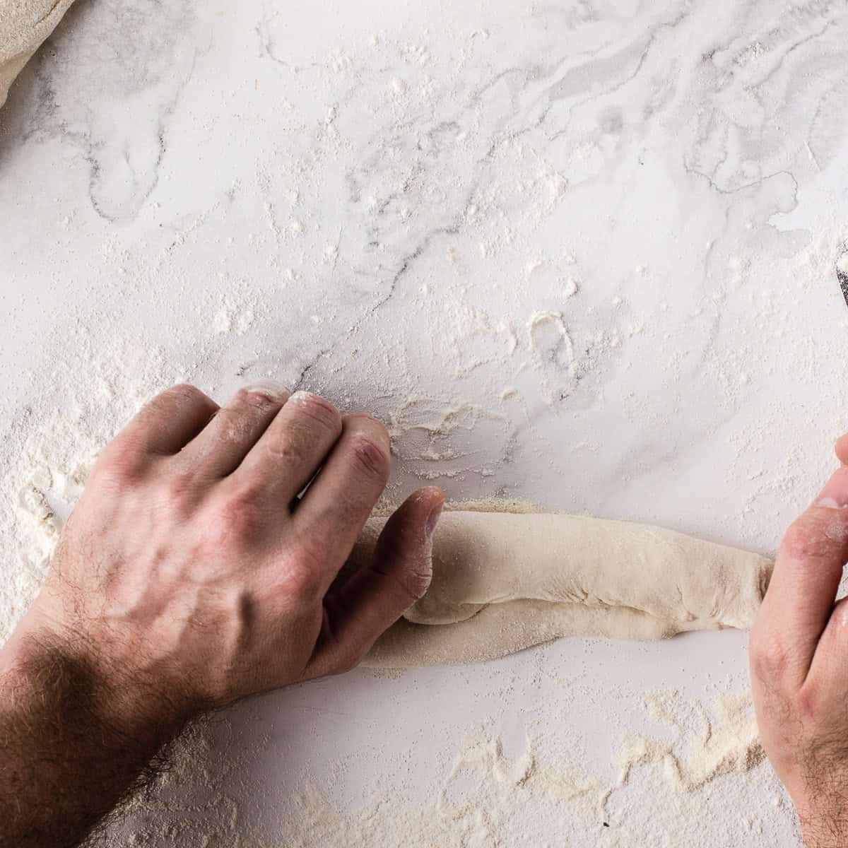 Sealing baguette with the palm of a hand.