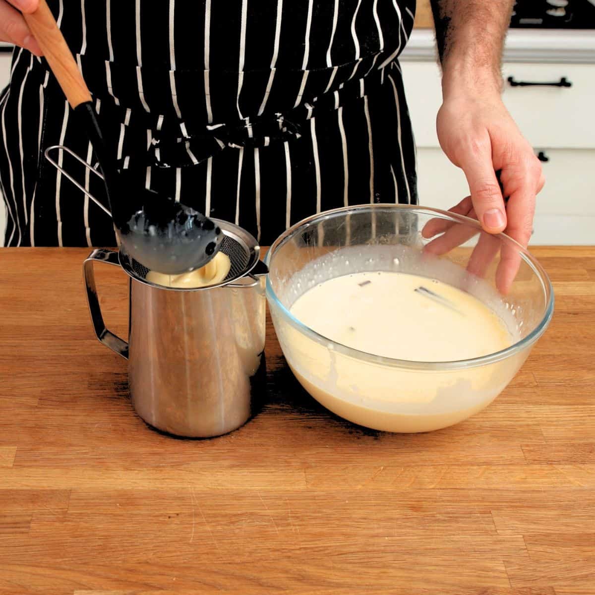Straining custard through a sieve.