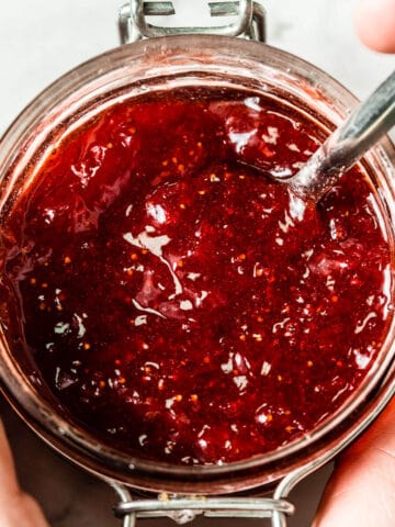 red strawberry jam in clear glass jar viewed from the top