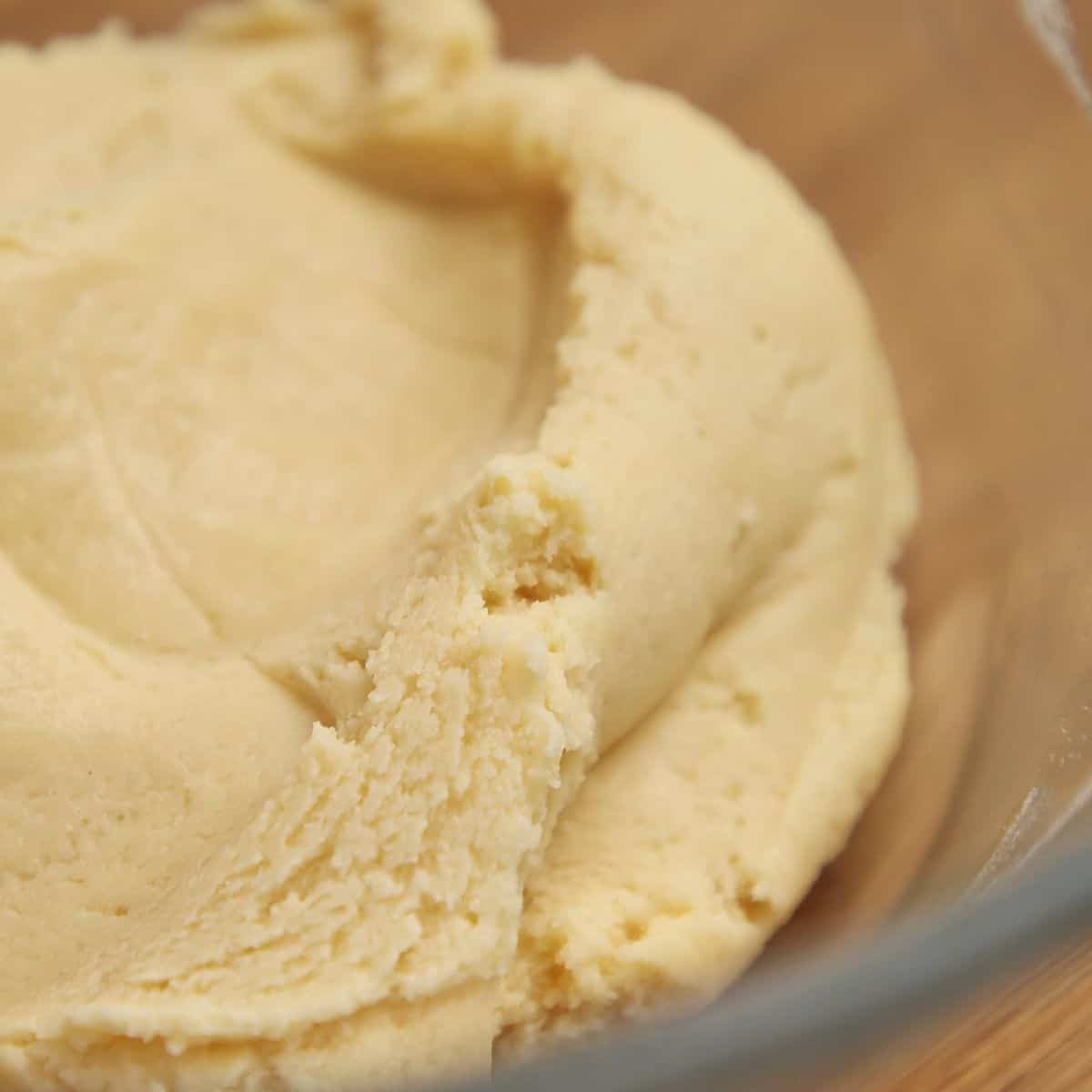 Tennis biscuit dough coming together into a smooth, cohesive ball in hands