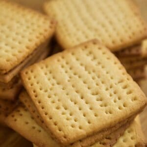 Golden square tennis biscuits stacked on top of each other.