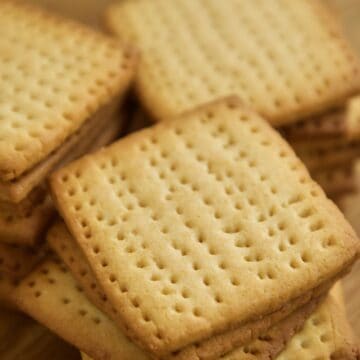 Golden square tennis biscuits stacked on top of each other.