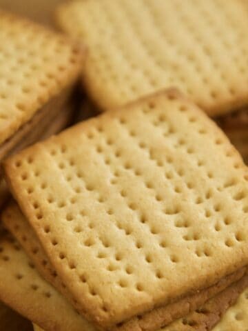 Golden square tennis biscuits stacked on top of each other.