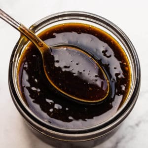 teriyaki sauce on spoon and in mason jar.