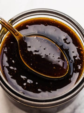 teriyaki sauce on spoon and in mason jar.