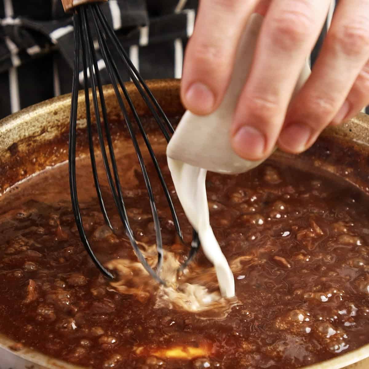 Thickening onion gravy with a cornstarch slurry.