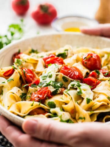 Cherry tomato and mozzarella pasta in a white pasta bowl.
