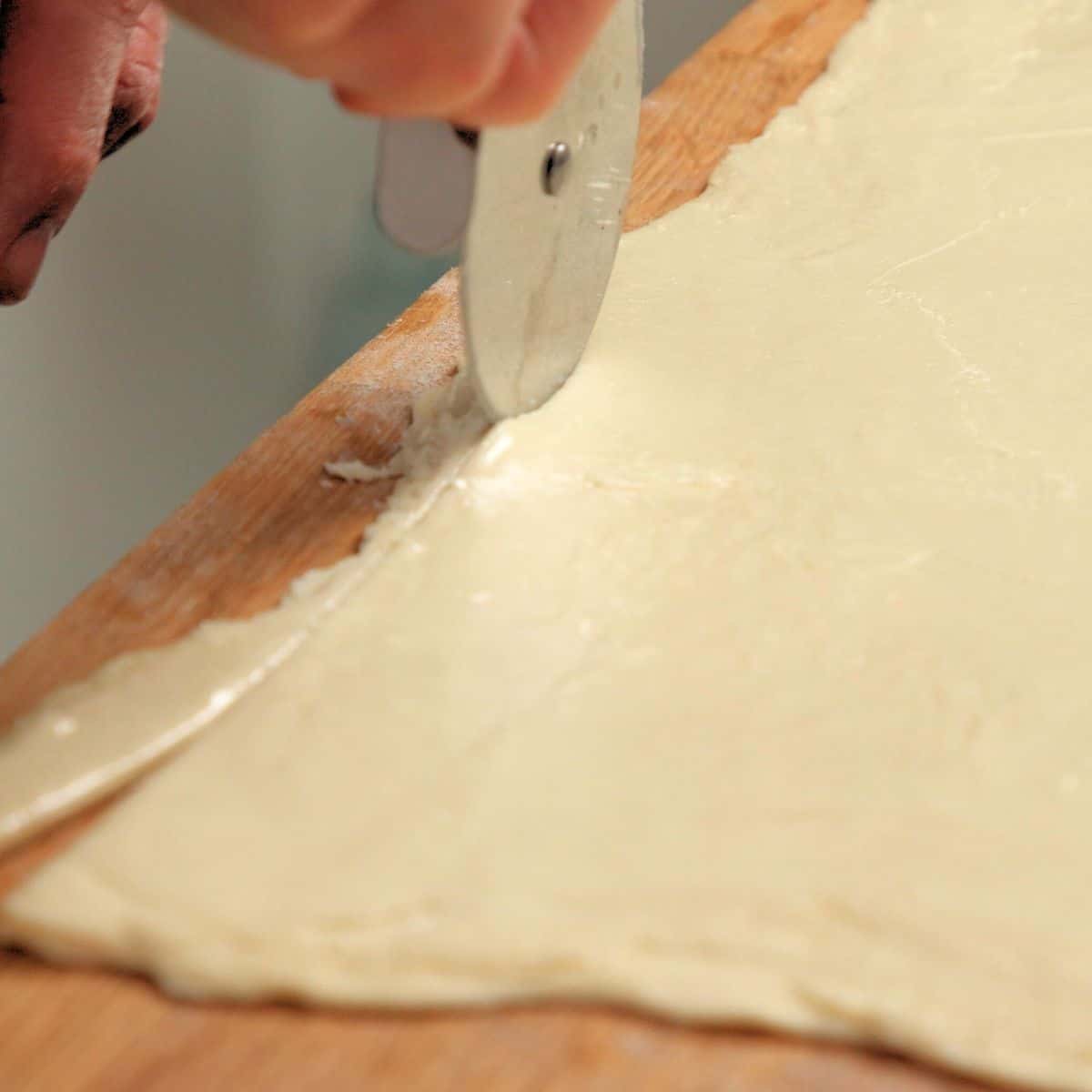 Trimming pastry with a rolling cutter.