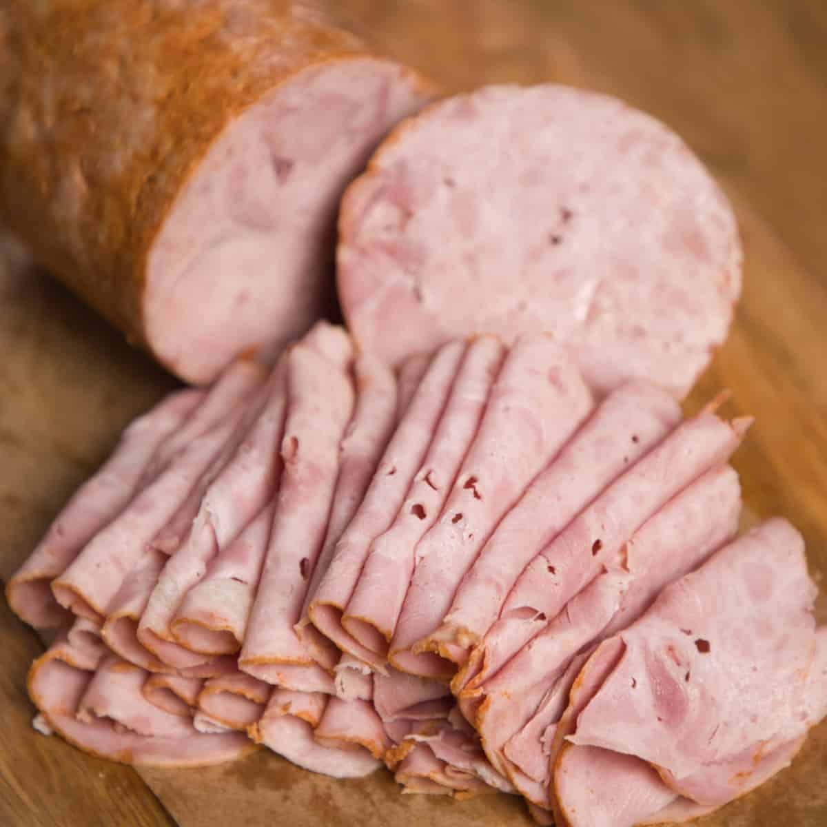 Cold cut turkey deli ham or lunch meat sliced on a wooden board.