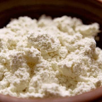 Cheese curds, farmer's cheese or tvorog in a brown bowl.
