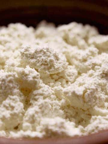 Cheese curds, farmer's cheese or tvorog in a brown bowl.