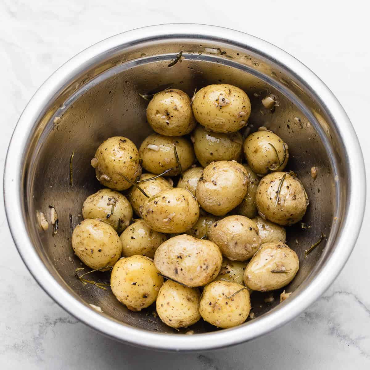 baked baby potatoes in stainless steel bowl on marble