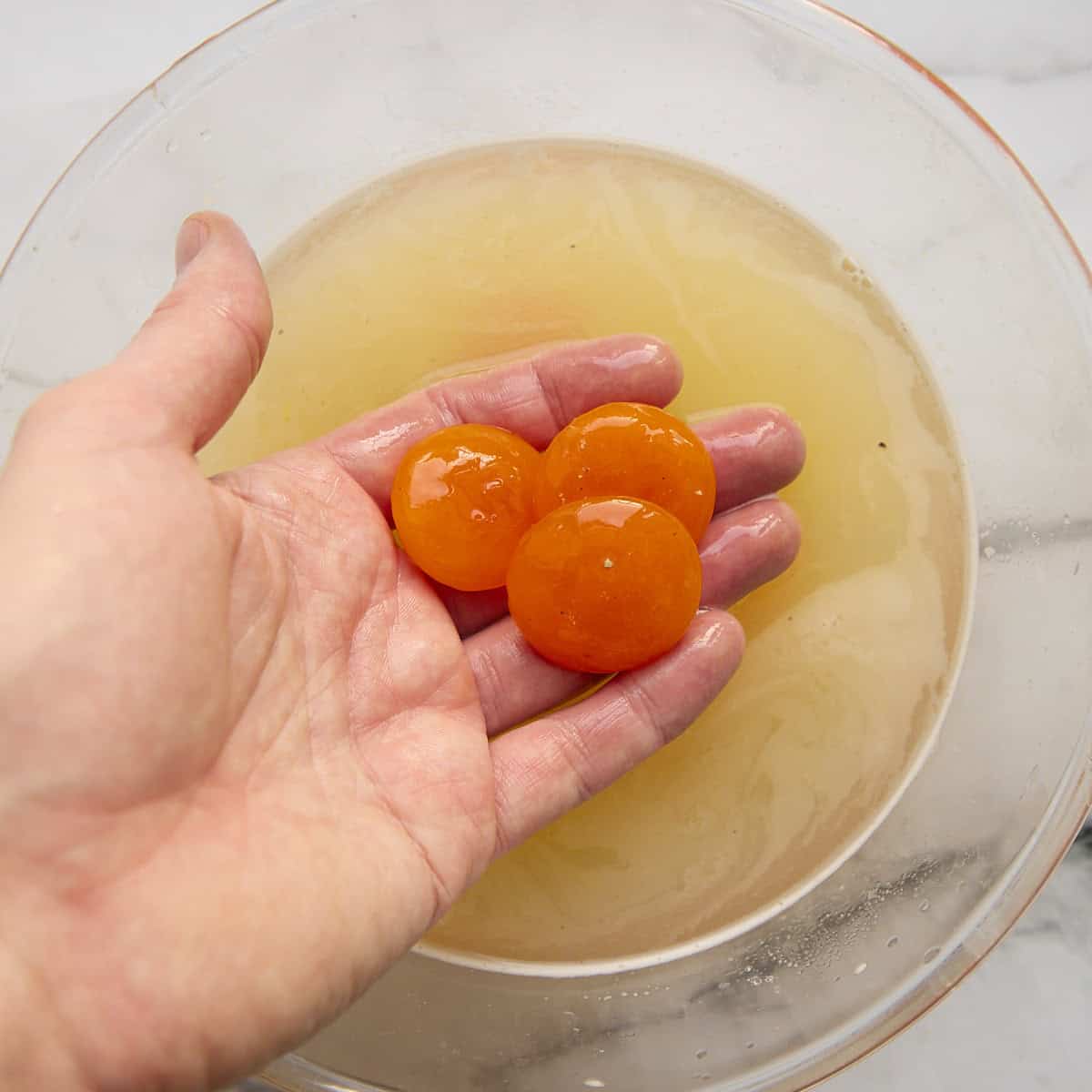 Washing egg yolks in a bowl of clean water.