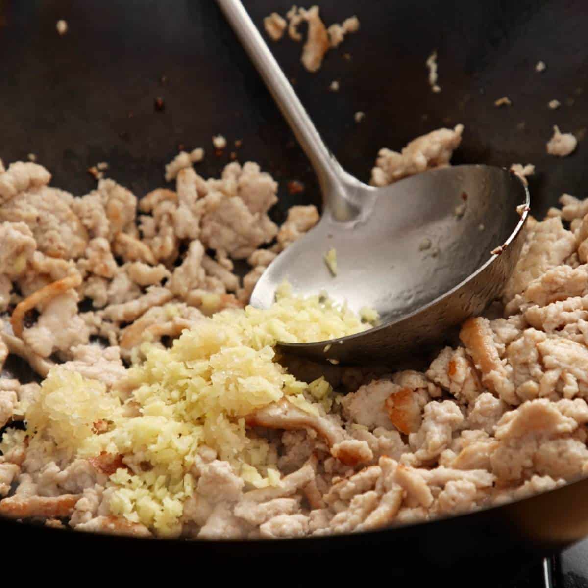 Wok frying chicken mince for spring rolls.